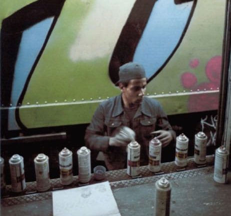Dondi en train de peindre entre deux trains